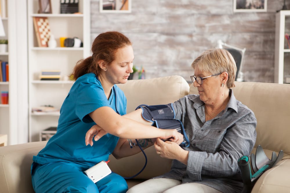 Nurse checking a client's blood pressure at home