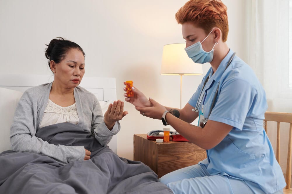 Nurse giving a client their medication at home